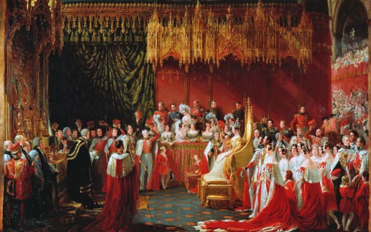 A painting of the coronation of Queen Victoria. Victoria is wearing a white and gold dress and sat on a large gold chair. There are people surrounding her wearing red robes with white trim. Some people are sat in a box watching the queen wearing formal attire. The background is ornate and coloured gold red and green.