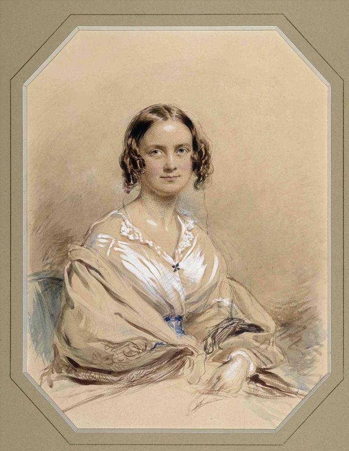 A portrait of Emma Darwin using chalk and watercolour. Darwin is seated in a white dress with a blue belt and a shawl covering her arms. Darwin is looking pleasantly at the artist with her hair in ringlets framing her face. 