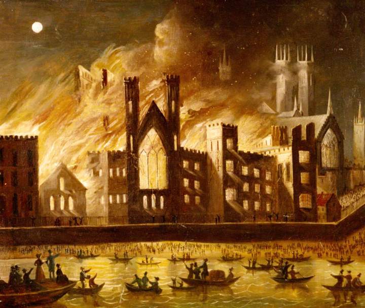 A landscape painting of the fire of 1834. Set in the evening with a full moon in the top left of the painting, in the main body of the painting is the palace of westminster engulfed in flames roaring over the roofs of the building, and windows expelling bright yellow light to below, On the walkway underneath the building, the faint silhouette of people are running away or calling for help. In the foreground and at the bottom of the painting is the River Thames, bathed in yellow reflections. There are multiple small boats out on the with people pointing and looking at the fire. Seemingly low tide, on the bank of the river are hundreds of silhouettes of people looking up at the fire. 