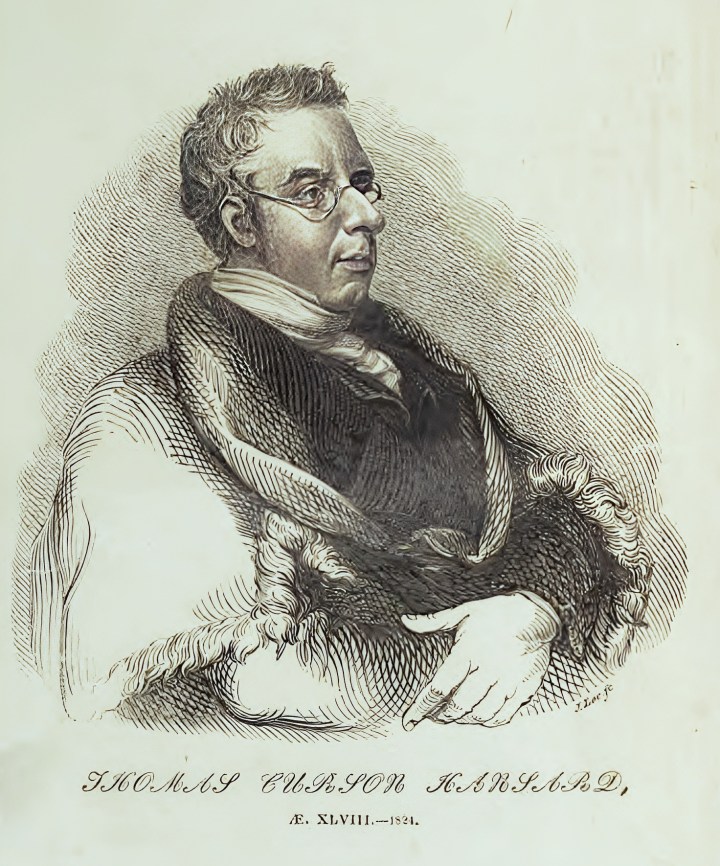 A black and white sketched half-length portrait of a man sitting down. Looking towards his left, he is wearing a black suit jacket with a thick white cravat, with a fur-lined throw over his shoulders. He is clean shaven with small round spectacles and short hair. The caption underneath reads 'Thomas Curson Hansard'. 