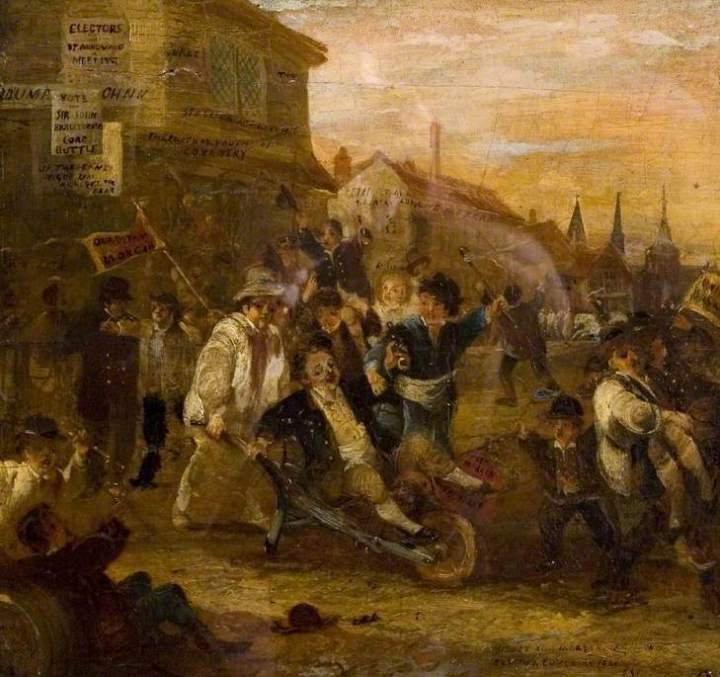 An oil painting of an election riot in Coventry (1861), where in the middle of a road, a rauvous crows with banners and flags are rioting. In the middle  a man is being wheeled around in a wheelbarrow. 